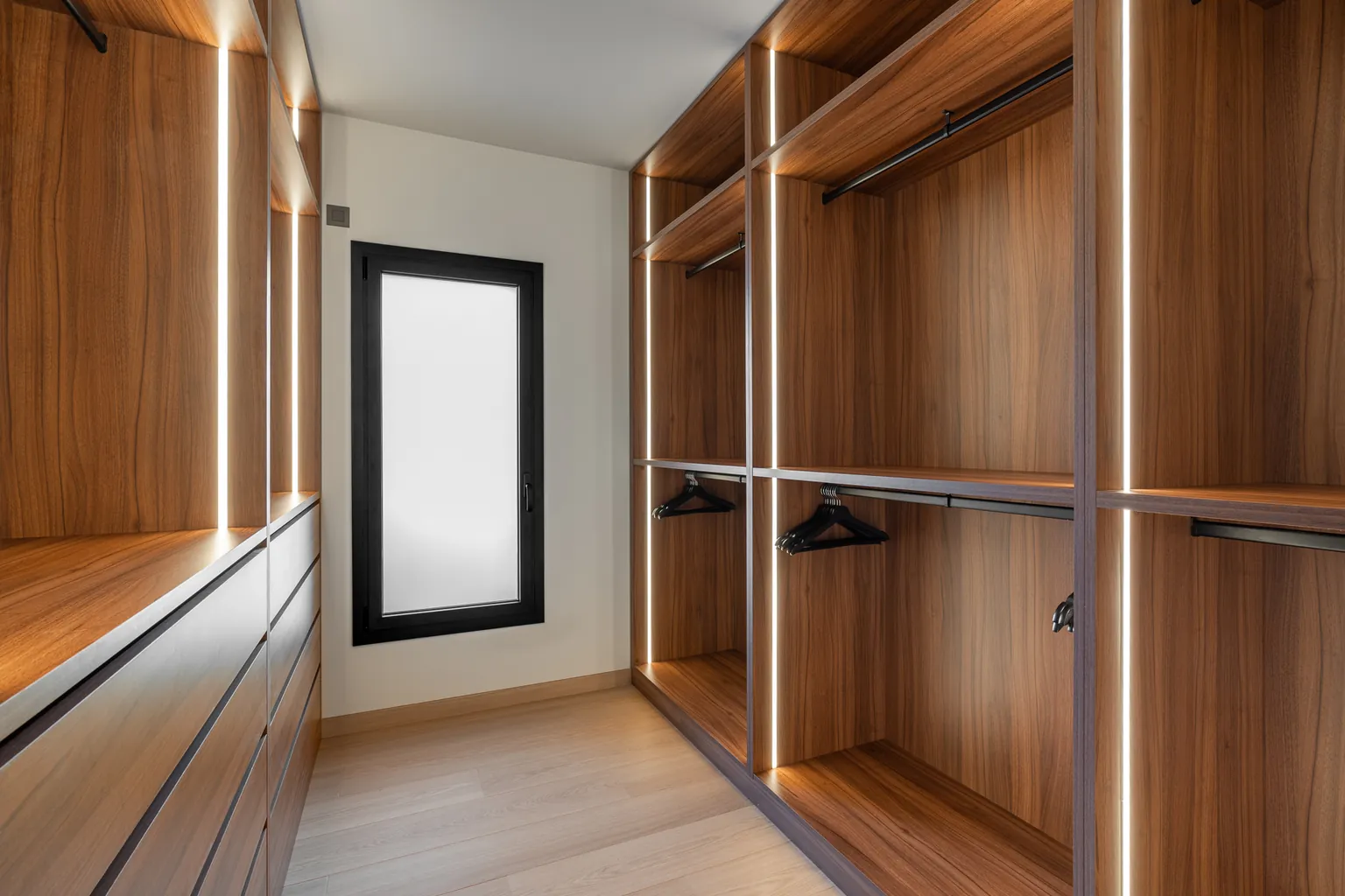 Made-to-measure wooden dressing room with integrated LED lighting, hanging rails and drawers