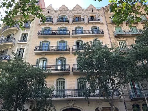 Modernista façade of the building in the Eixample with wrought-iron balconies, louvred shutters and ornamental crowning