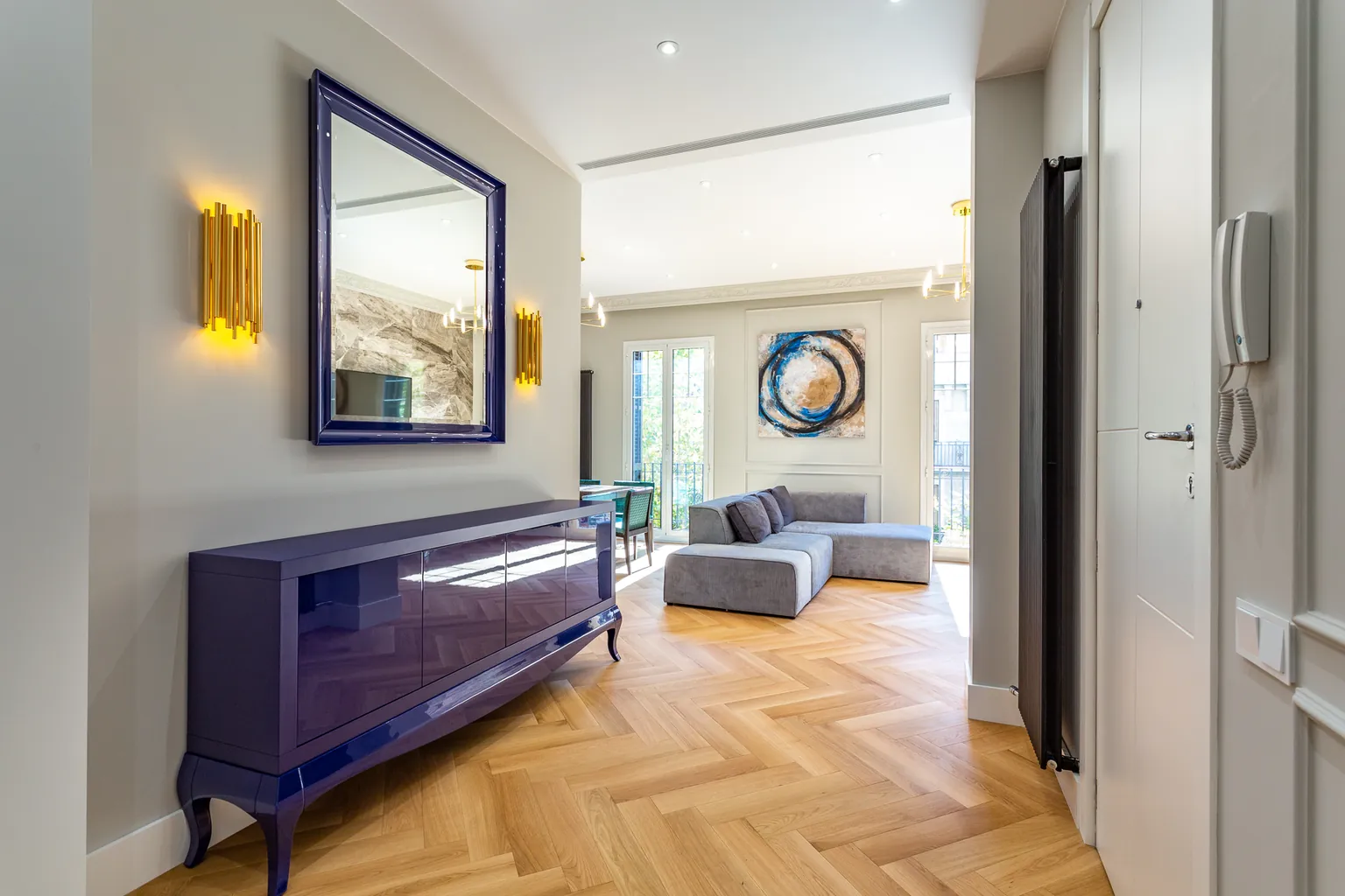 Entrée avec parquet en bois naturel à bâtons rompus, moulures murales et radiateur vertical IRSAP