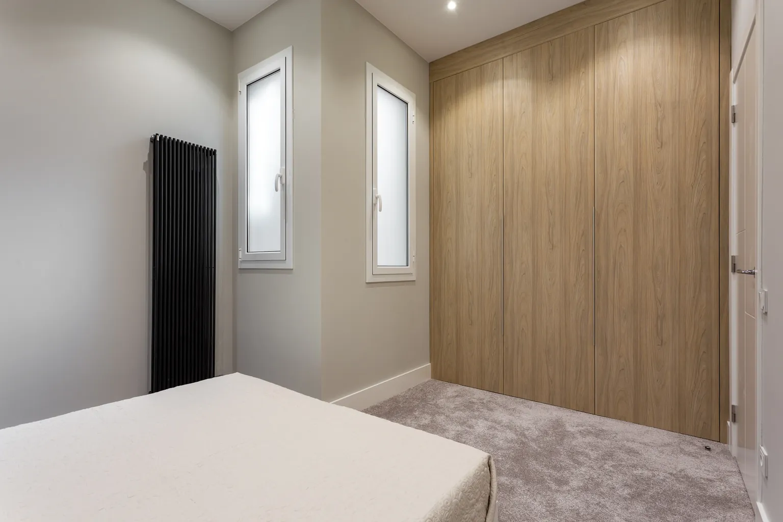 Chambre avec placard intégré du sol au plafond en bois et radiateur vertical design IRSAP